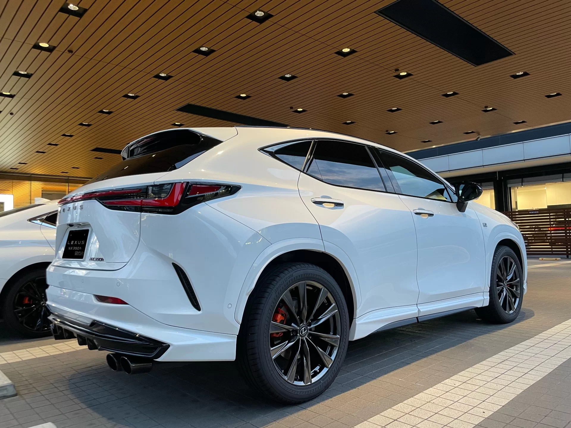 レクサス NX350h F SPORT 2023年式 ホワイトノーヴァガラスフレーク F SPORT PARTS エアロダイナミクスパッケージ(フロントスポイラー・エアロダイナミクスミラーカバー・サイドスカート・リヤディフューザー・スポーツマフラー) リヤ右斜め